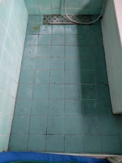 洗い場の床です。
目地に黒カビが付着し、タイル面には水アカや石鹸カスが付着して白く浮き上がっています。